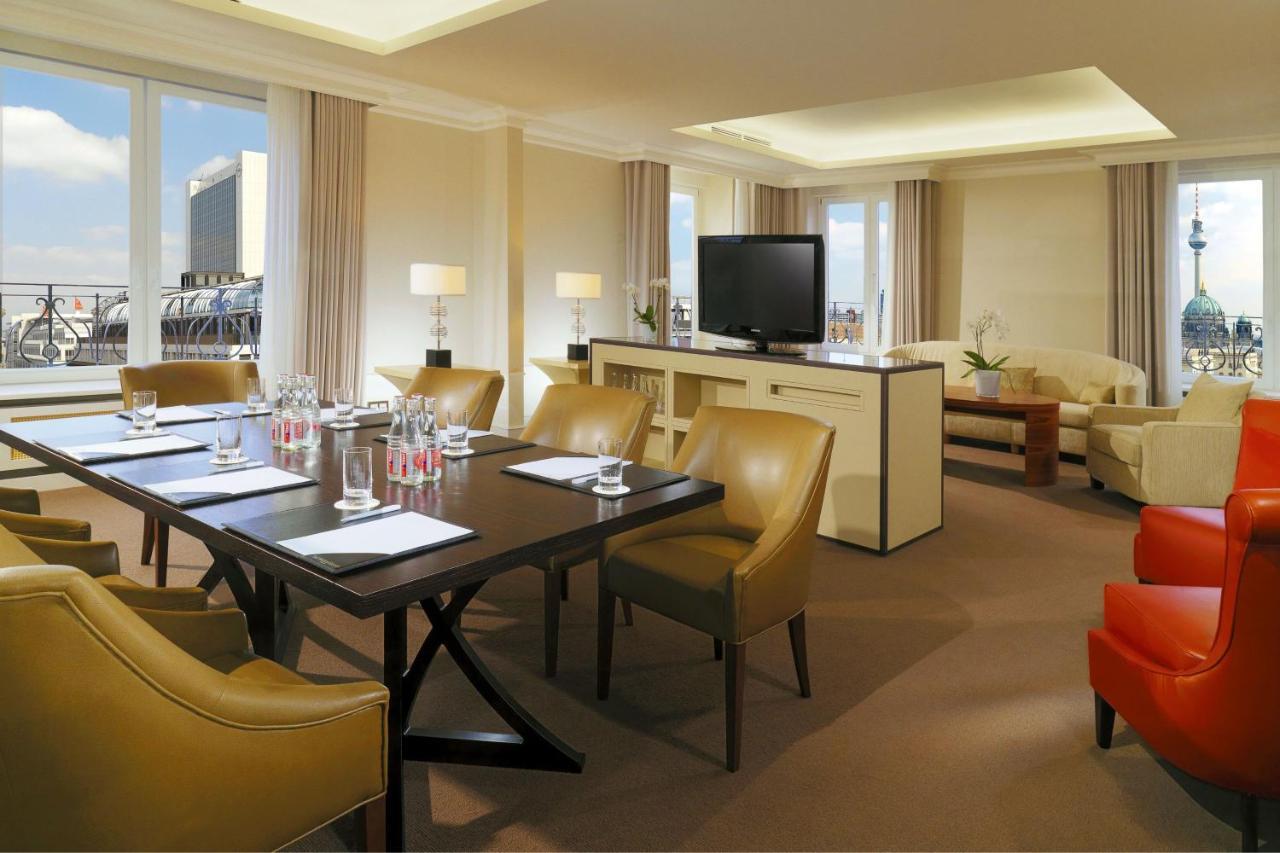 Hotel The Westin Grand Berlino Esterno foto The photo depicts a well-appointed hotel or conference room. It features a large table surrounded by several beige chairs, suggesting it’s set up for a meeting or gathering. On the table, there are water bottles and notepads, indicating preparation f